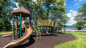 A playground with a slide, climbing structures, and a gazebo. - The Family Clubhouse at Abbey Springs (Fontana)