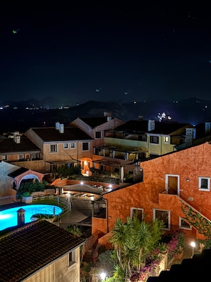 A residential area with houses, a swimming pool, and a mountainous backdrop. - Apartment 'C 210 Puntavilla' with Shared Pool, Wi-Fi, and Air Conditioning (La Maddalena)