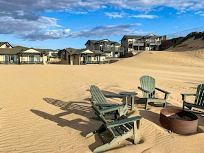 A beachside hotel with outdoor seating and a fire pit.