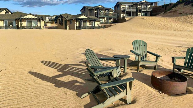 Un complexe hôtelier situé en bord de mer, composé de plusieurs bâtiments, doté d’espaces de détente en plein air et d’un foyer.