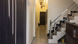 A modern interior with a marble floor, a staircase, and a security camera. - Gita Raman Palace (Ayodhya)