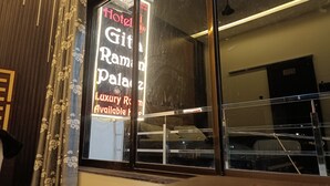 A hotel entrance with a large glass window displaying 'Hotel Git Rami Palace' and 'Luxury Room Available.' - Gita Raman Palace (Ayodhya)