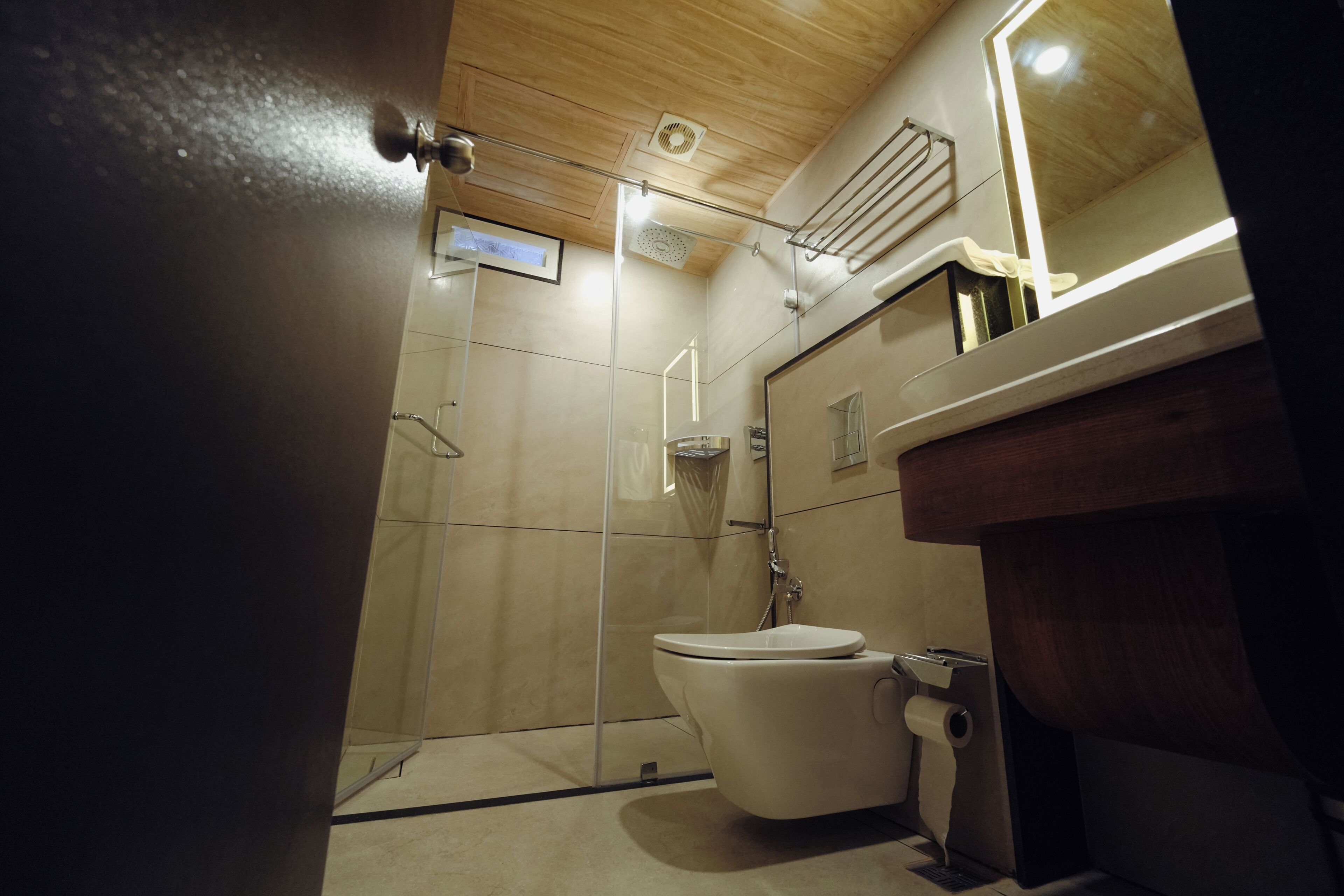 A modern bathroom with a glass-enclosed shower, a toilet, and a vanity with a mirror.