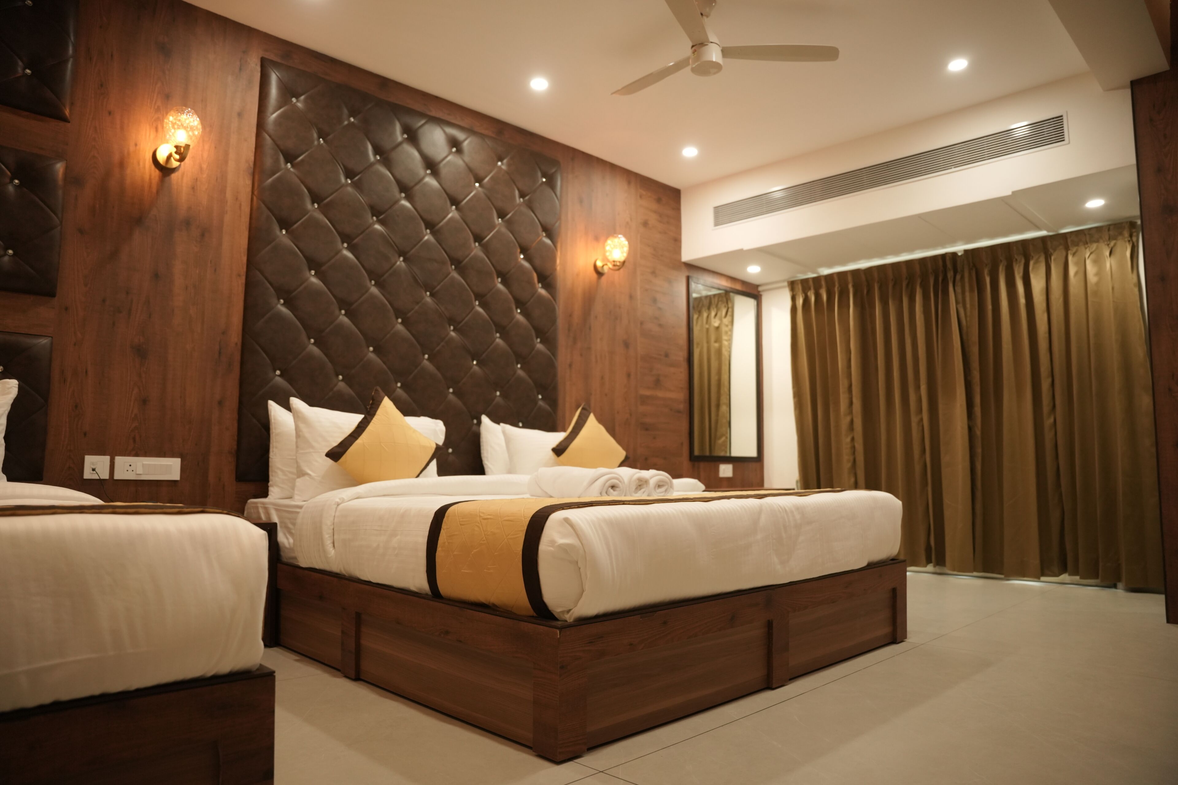 A bedroom with a large bed, a wooden headboard, two bedside tables, and a ceiling fan.