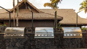A stone wall with two stainless steel barbecue grills. - Two 2BR Condos, Pool, Hot Tub, Prime location (Kailua-Kona)