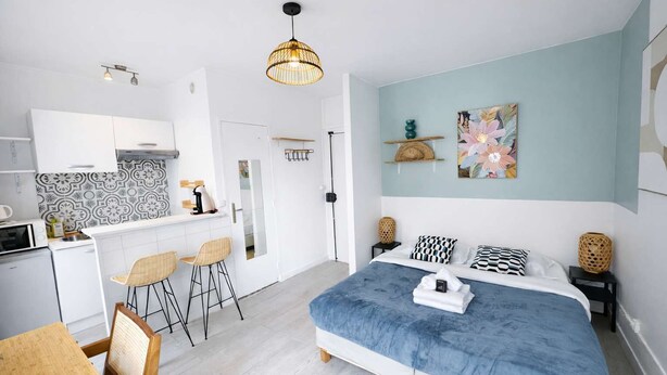 Quarto moderno com cama, mesas de cabeceira, escrivaninha e uma cadeira.