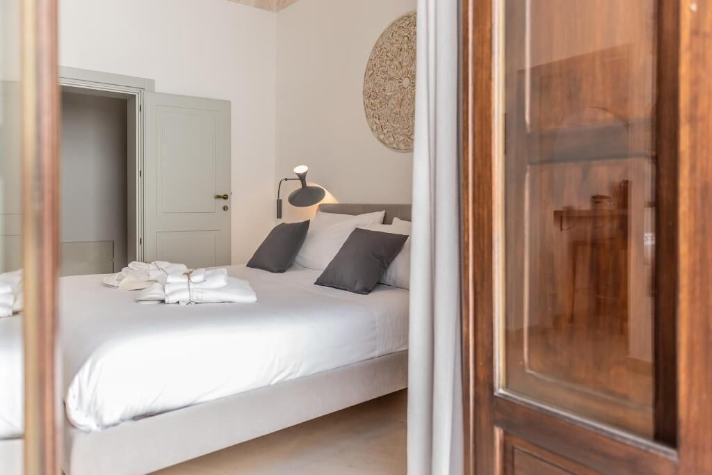 Un dormitorio con cama, lámpara de noche y una puerta.