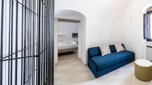 A modern interior with a blue sofa, a round ottoman, and a metal gate. - DOMUS SAN GIOVANNI (Locorotondo)