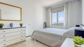 Ein Schlafzimmer mit Bett, Schminktisch, Spiegel und Fenster mit Blick.