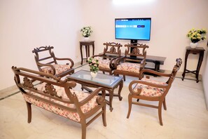 Un espace repas avec des meubles en bois et un téléviseur à écran plat fixé au mur.