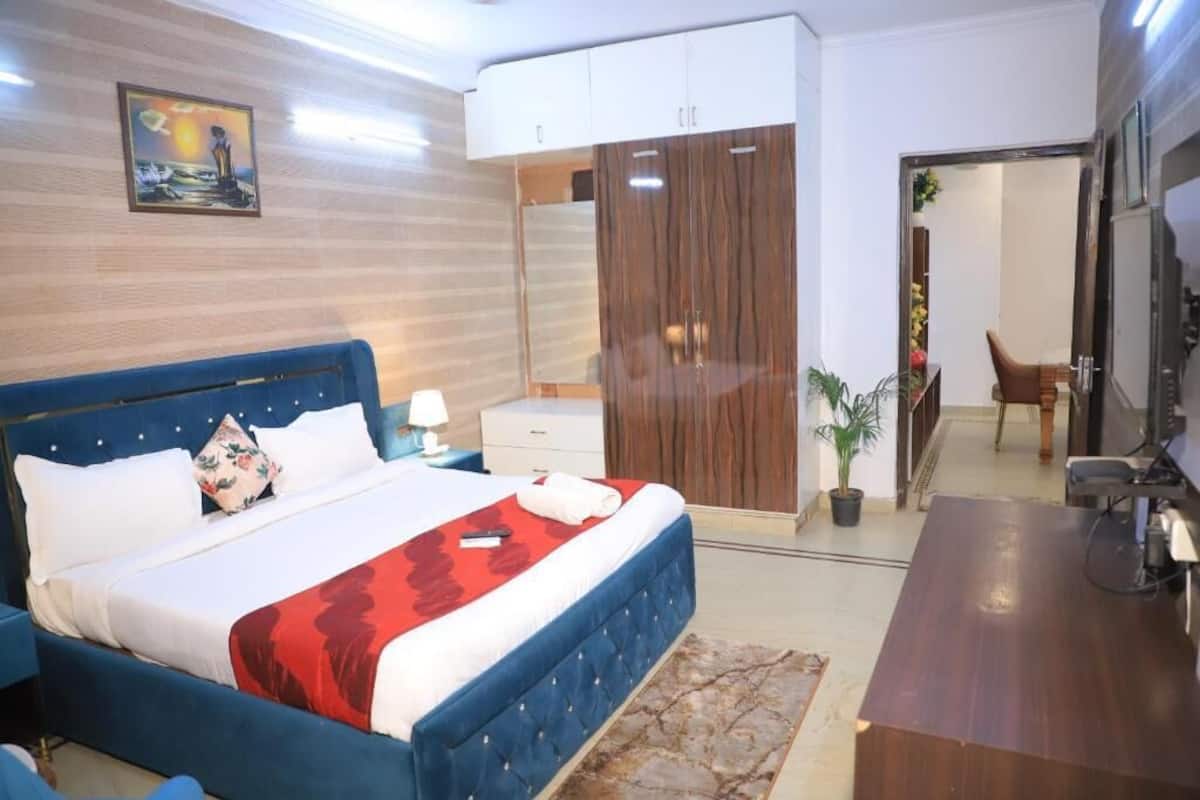 Een slaapkamer met een bed, een kledingkast, een bureau en een stoel.