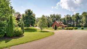 Il s'agit d'une propriété résidentielle dotée d'une allée pavée, d'une maison en bois et d'une pelouse bien entretenue.