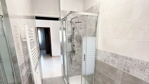 A modern bathroom with a glass-enclosed shower, a bathtub, and a sink. - Stabia Apartment (Angri)