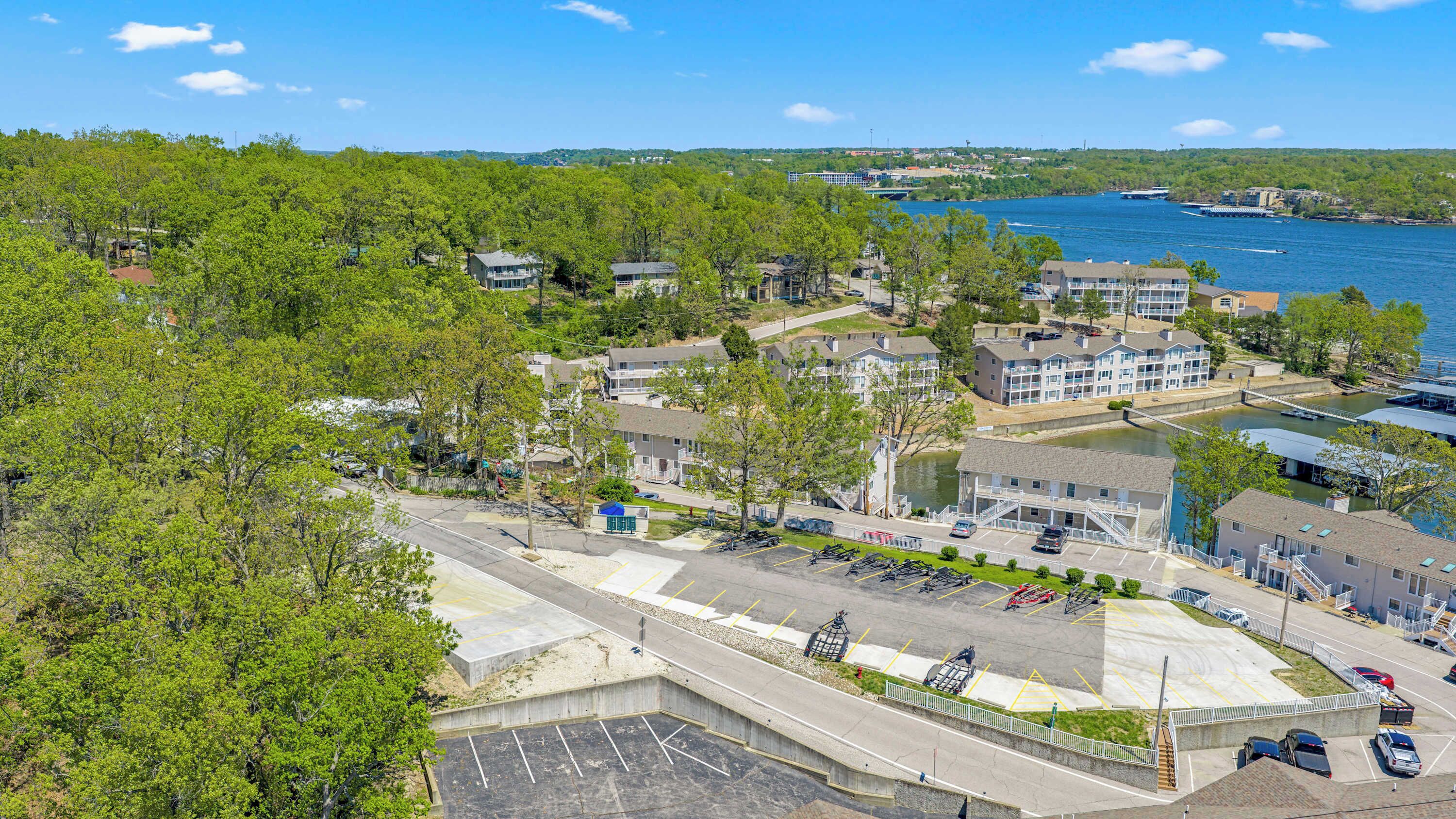 A coastal residential area with multi-story buildings, a marina, and a parking lot.