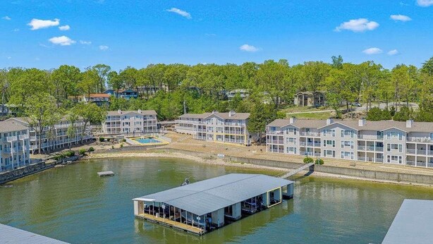 A waterfront property with multiple buildings, a dock, and a swimming pool. - Ozark Get-away Lakefront Condo With Boat Slip (Osage Beach)