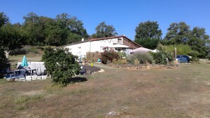A house with a garden, outdoor furniture, and a car parked nearby.