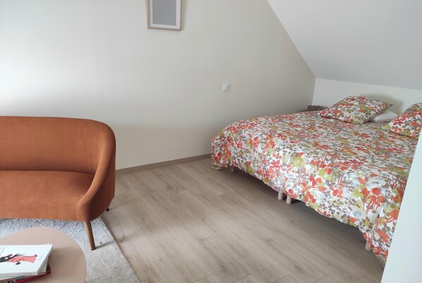 Une chambre à coucher avec un lit, une chaise et une petite table.