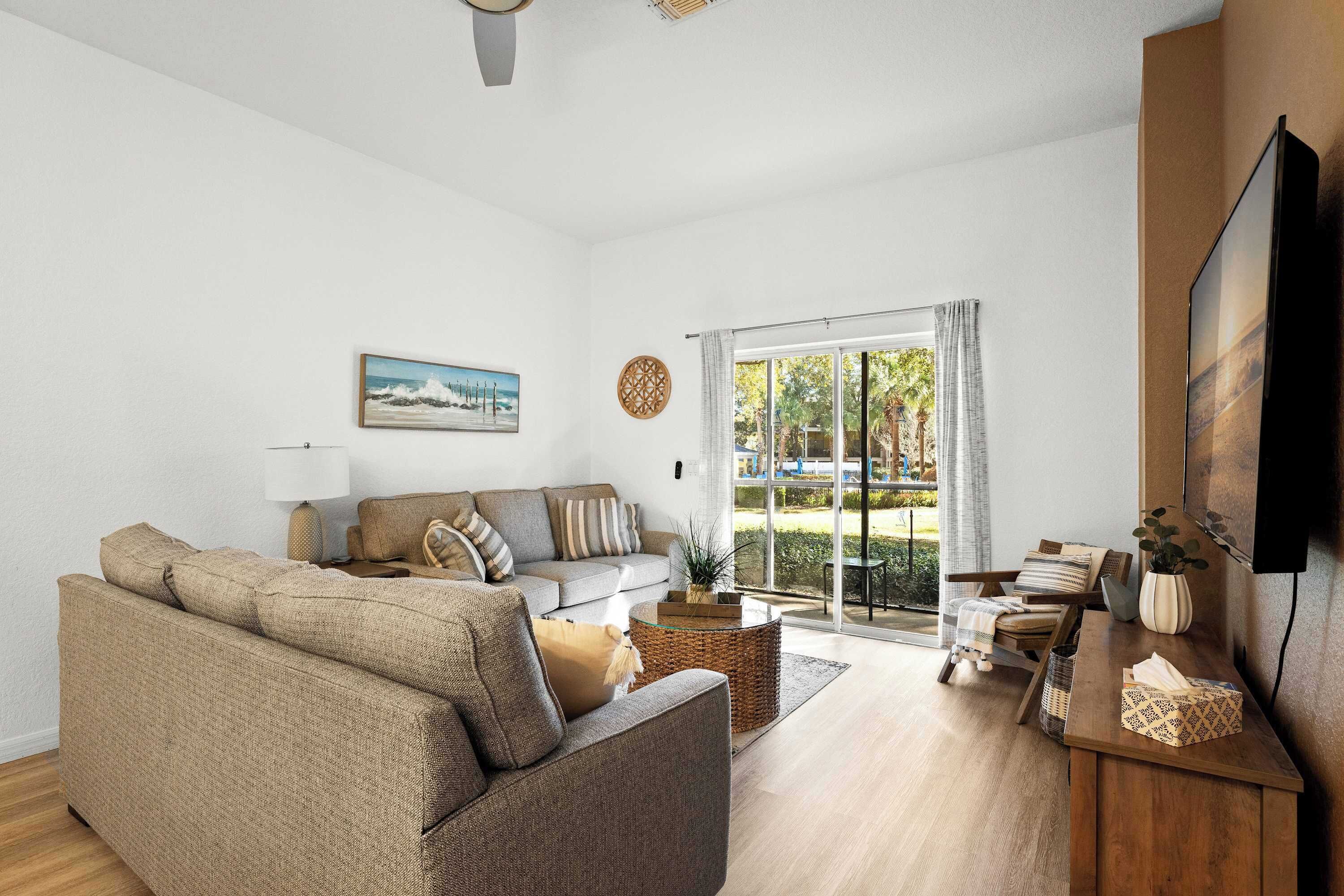 A modern living room with a sofa, a coffee table, and a TV.