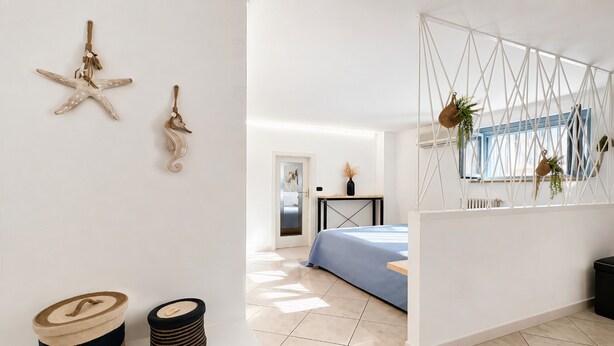 Een moderne slaapkamer met een bed, een wandplank en een deur naar een andere kamer.