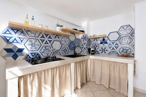 Frigorífico, placa de cocina, cafetera o tetera y utensilios de cocina