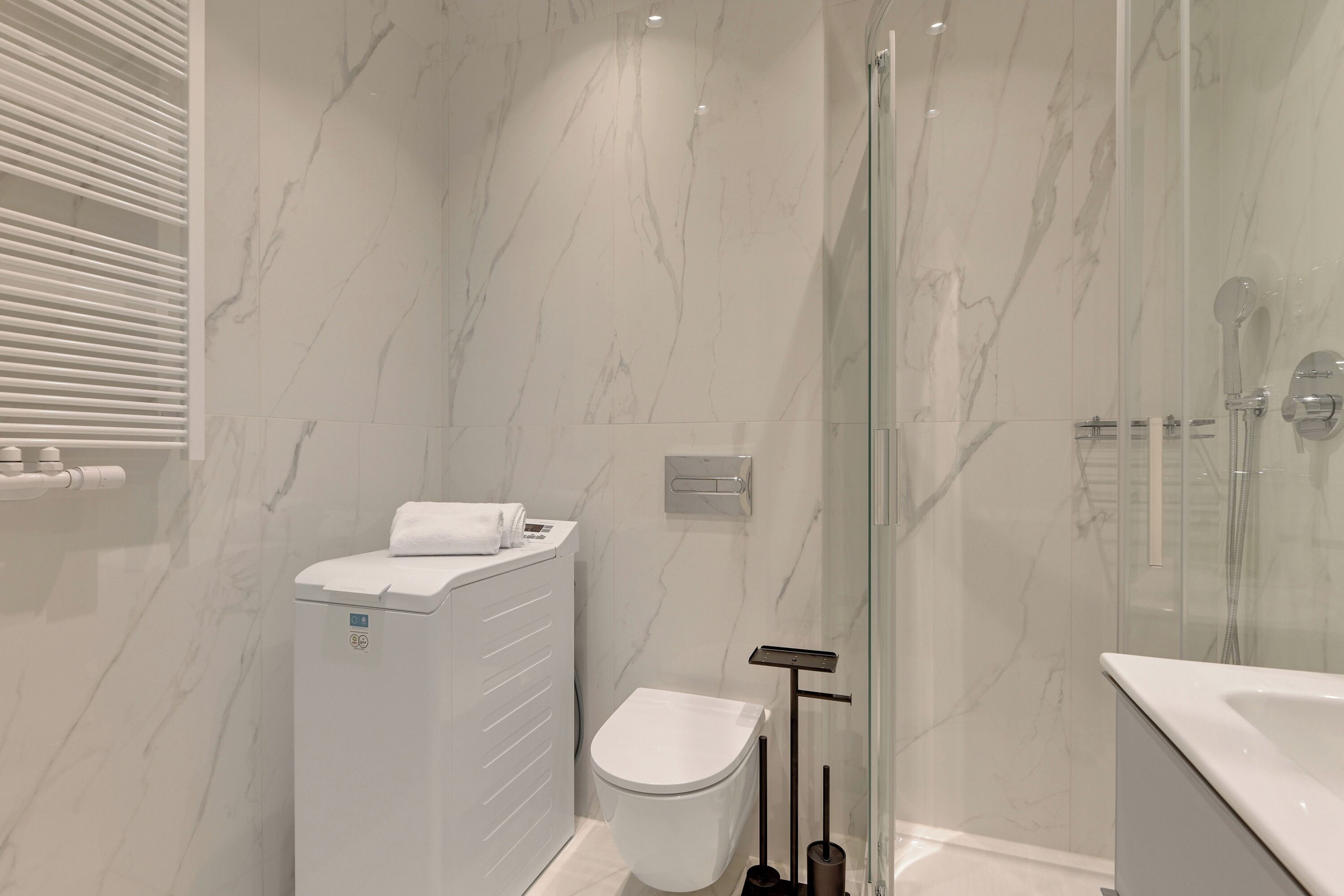 Un bagno moderno con WC, bidet e cabina doccia in vetro.