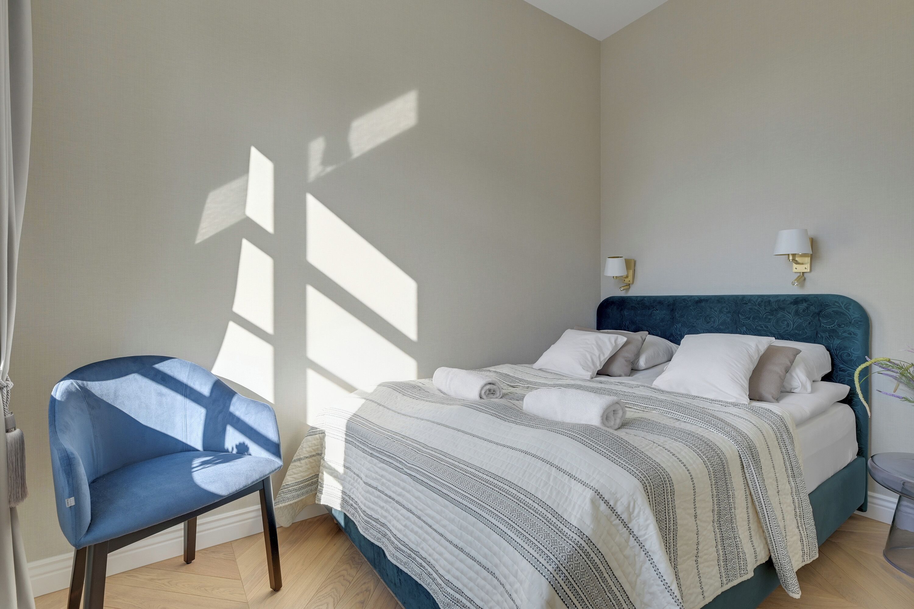 Un dormitorio con una cama, una silla y una mesita de noche.