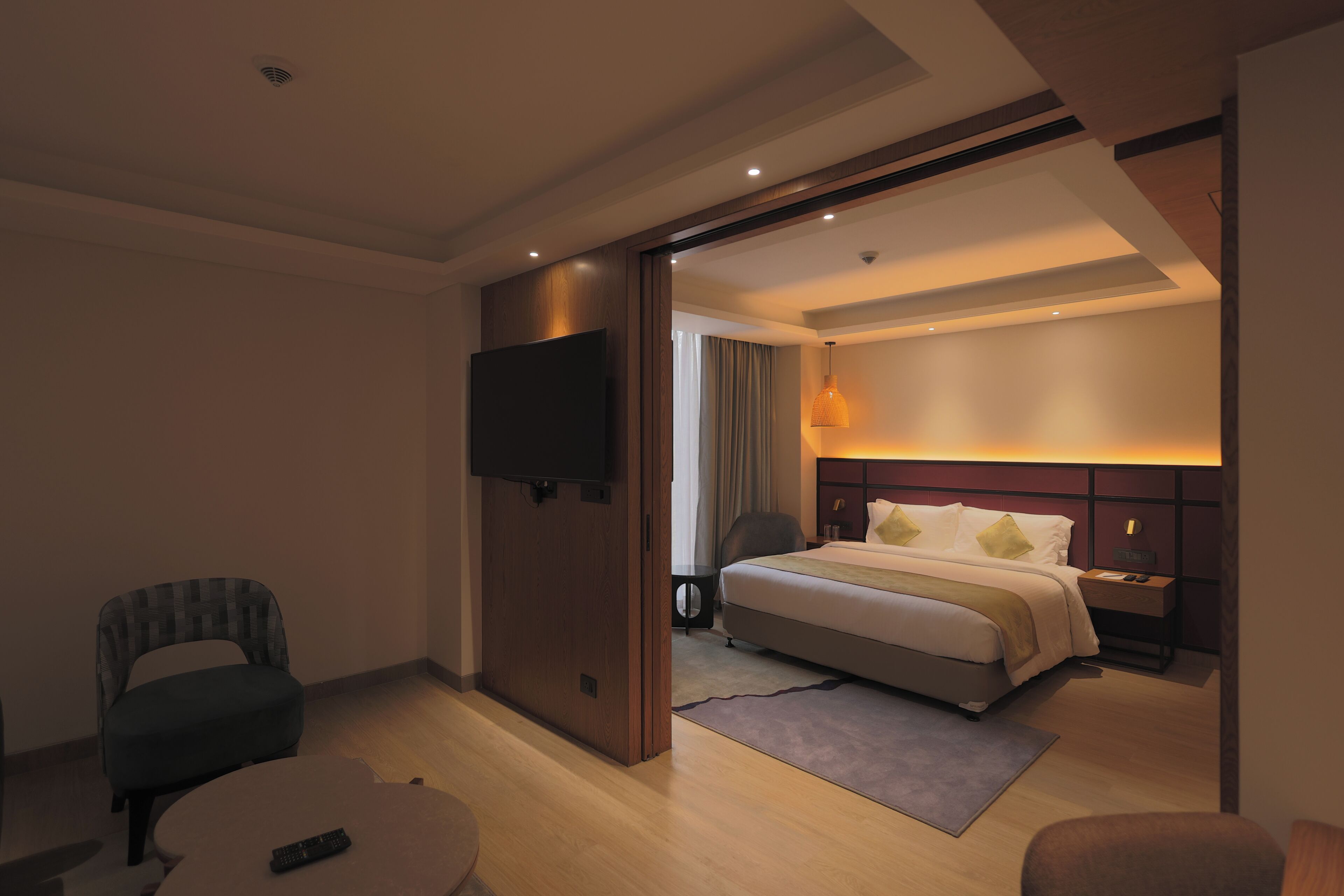 Una habitación de hotel con cama, televisión, escritorio y silla.