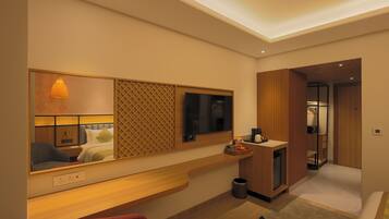 A modern hotel room with a large mirror, wooden console, and a small desk.