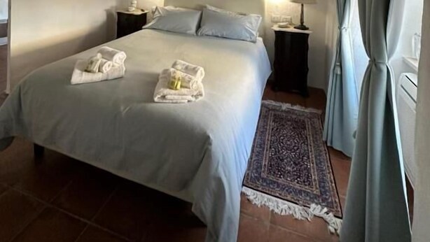 Une chambre à coucher avec un lit, deux tables de chevet, un tapis et un mur orné de tableaux.
