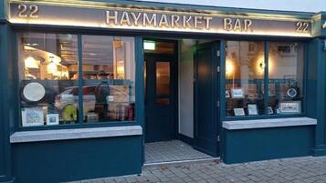 En butik med skiltet 'HAYMARKET BAR' og nummeret '22' over indgangen.