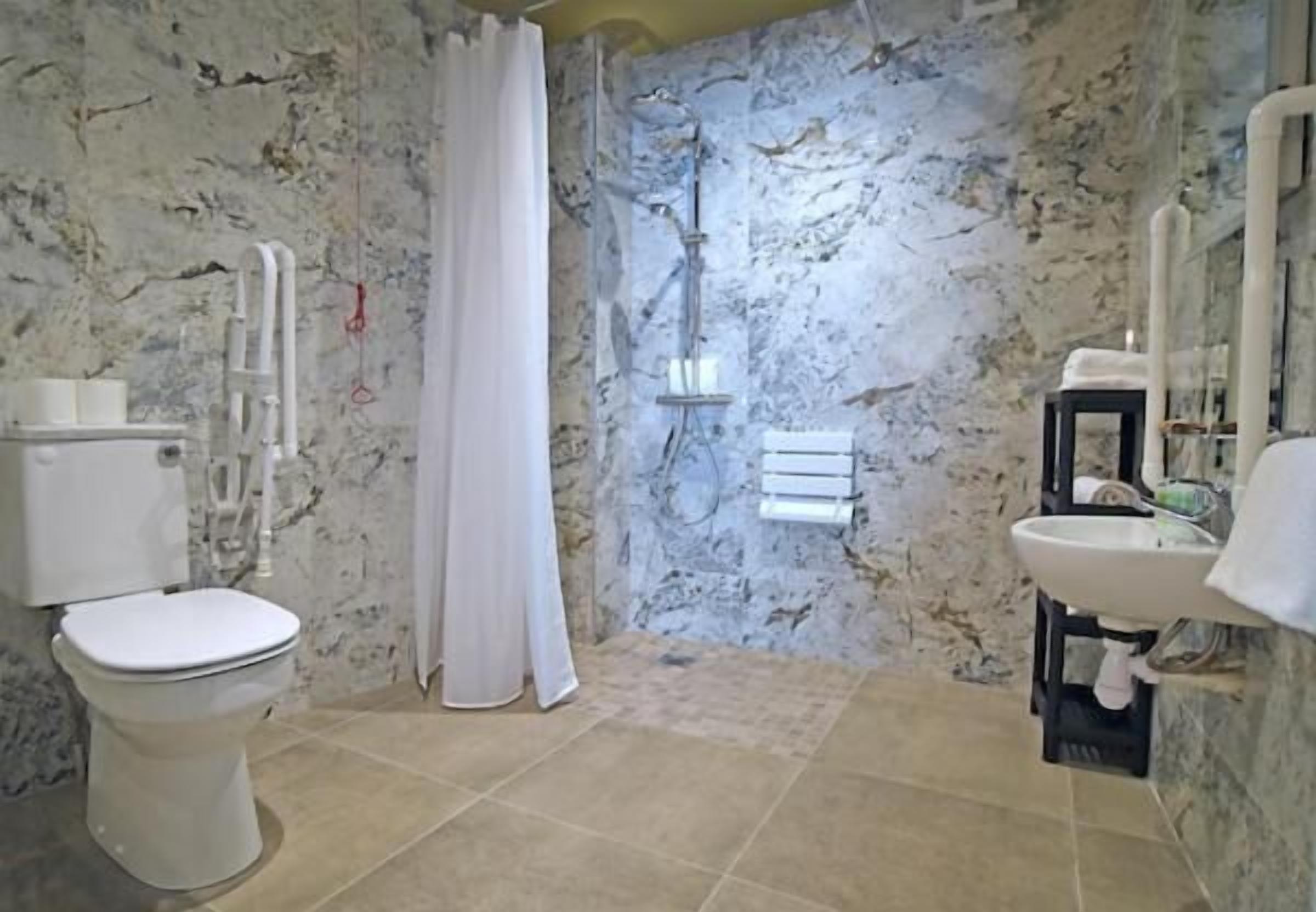 Un bagno con il water, la doccia e il lavandino.