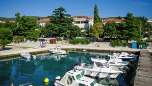 A marina with boats docked, a wooden dock, and buildings in the background. - Modern, fully equipped studio in a top location (Crikvenica)