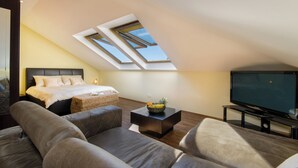 A modern loft bedroom with a large bed, a TV, and a skylight. - Modern, fully equipped studio in a top location (Crikvenica)