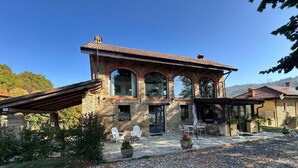 Un edificio in pietra con un patio, posti a sedere all'aperto e vista sul paesaggio circostante.