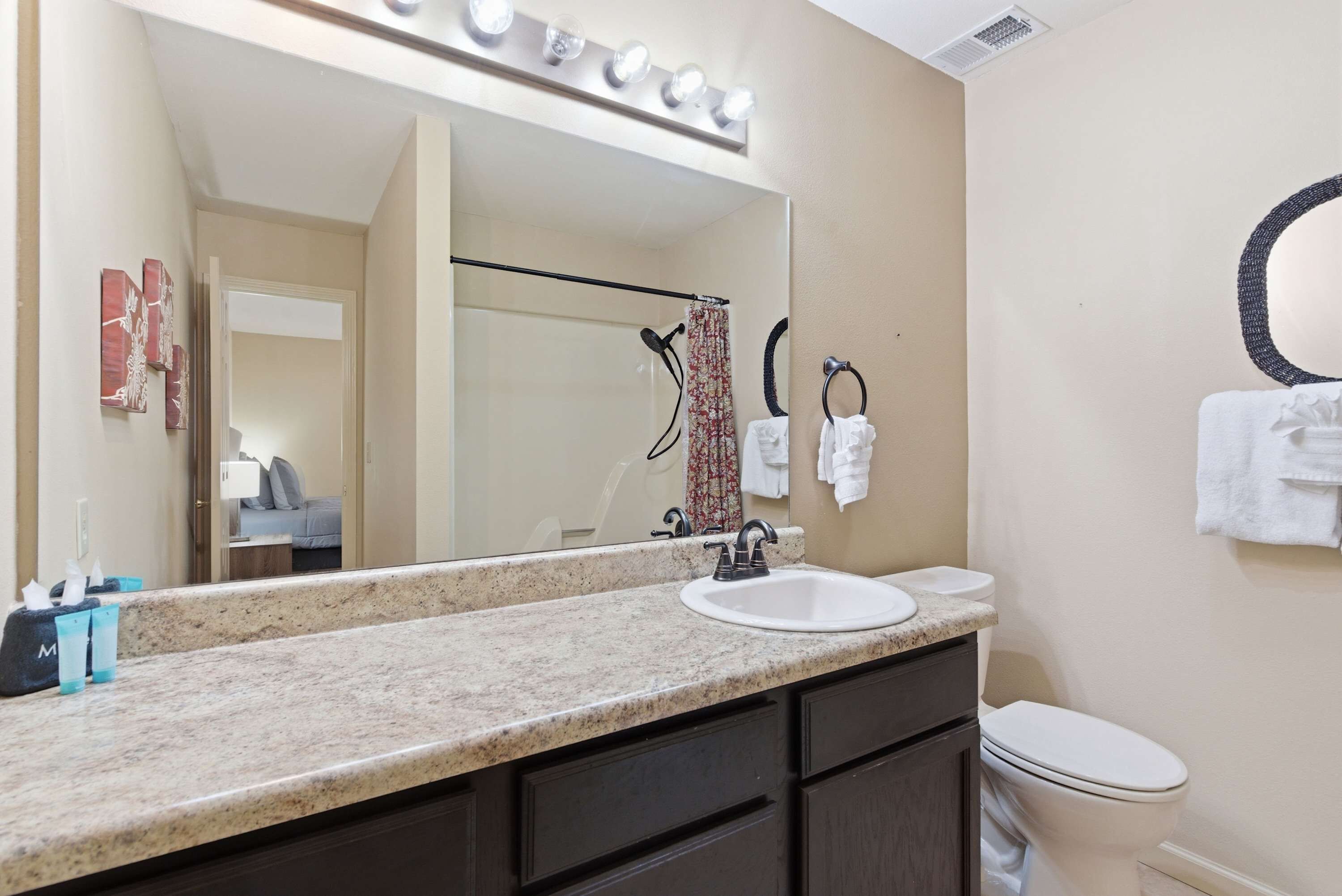 A bathroom with a sink, mirror, and towel rack.