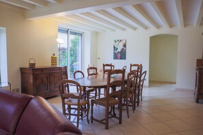 Un coin repas avec une table et des chaises en bois, un canapé en cuir et un meuble.