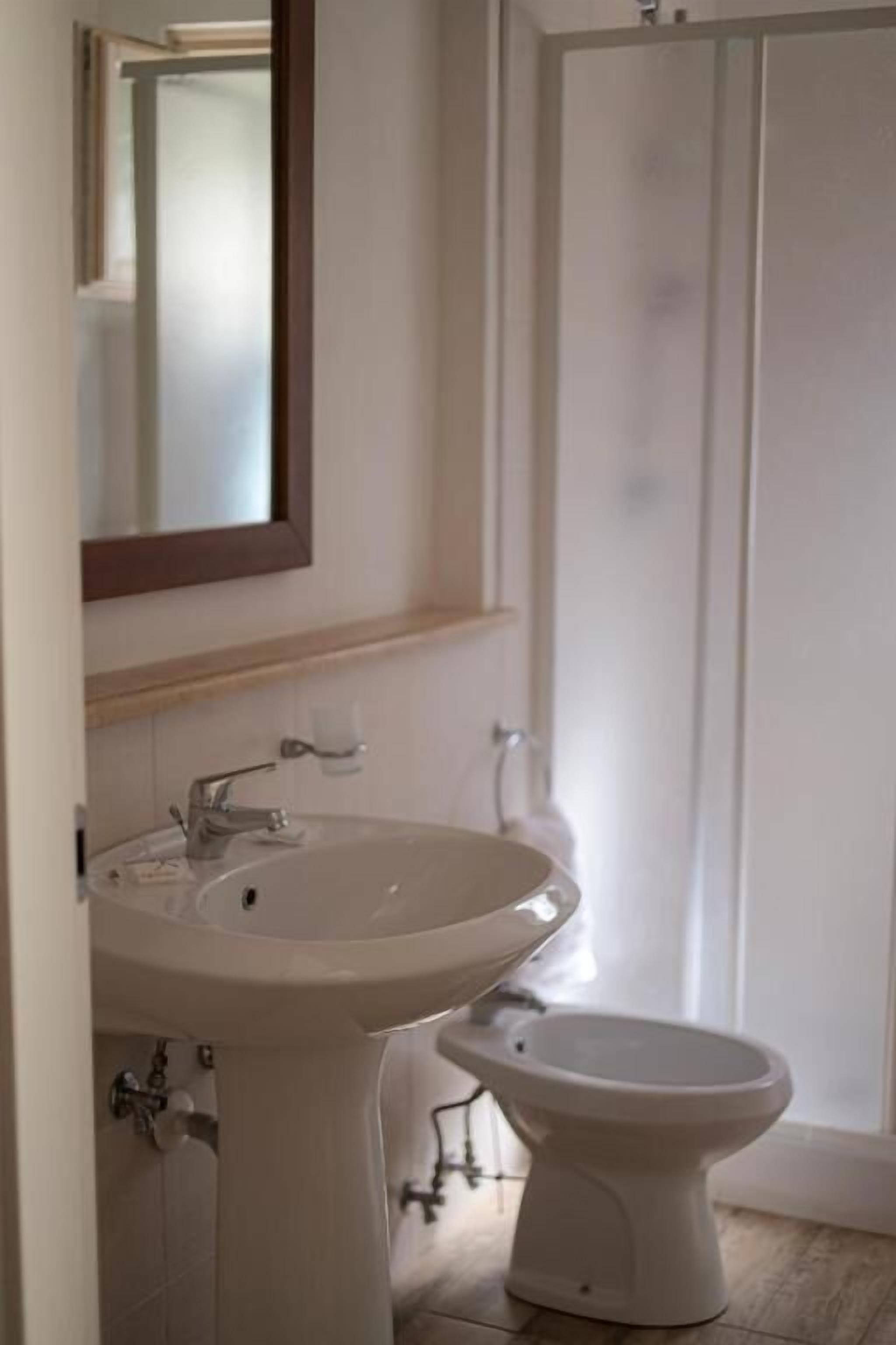Ein Badezimmer mit Waschbecken, Spiegel und Toilette.