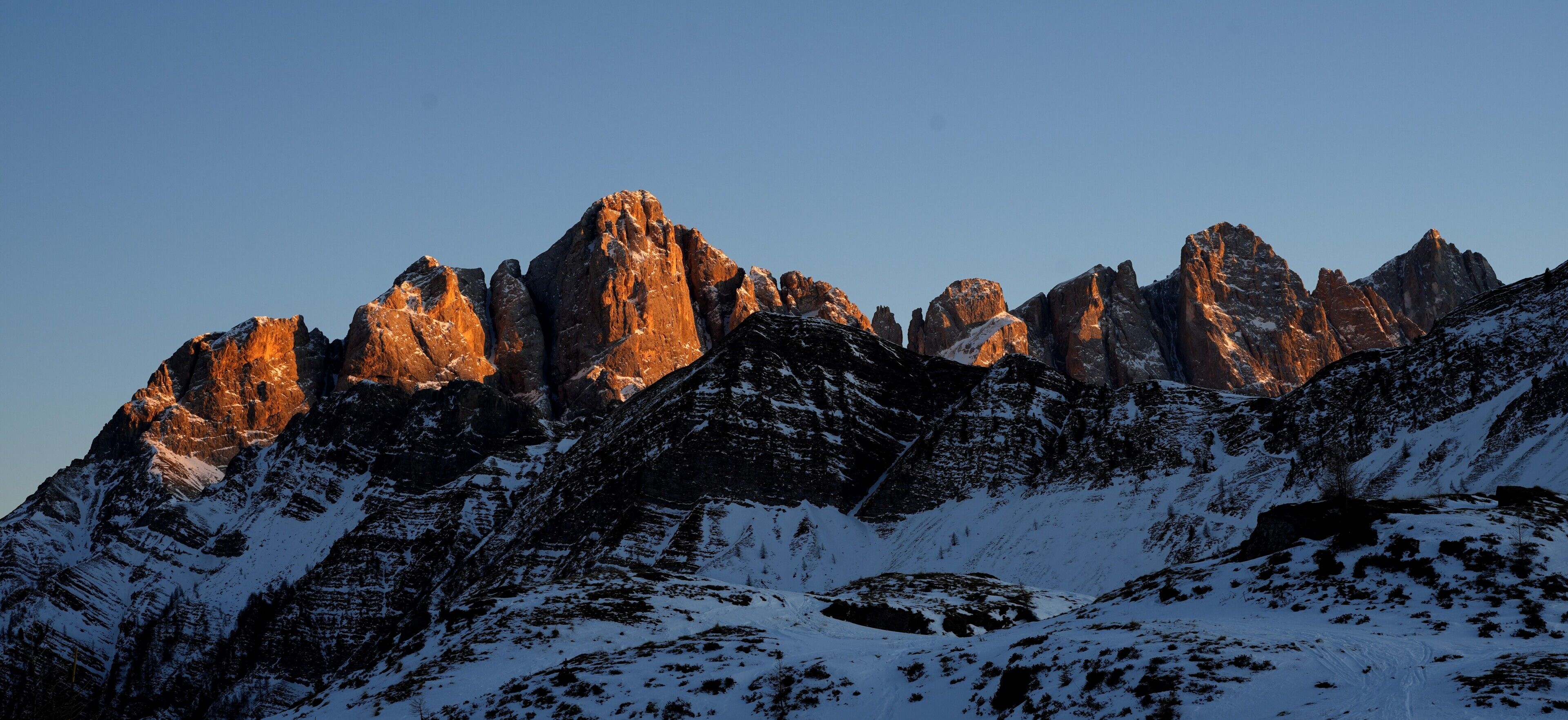 A mountainous landscape with snow-covered peaks and rocky outcrops.