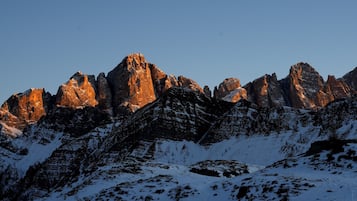 A mountainous landscape with snow-covered peaks and rocky outcrops.