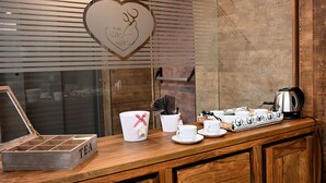 A wooden counter with tea service items, a heart-shaped decoration, and a kettle. - Mas dei Masi (Cavalese)