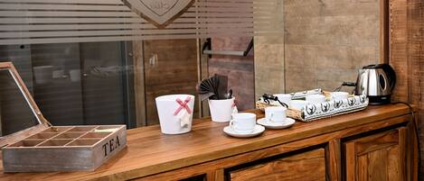 A wooden counter with tea service items, a heart-shaped decoration, and a kettle.