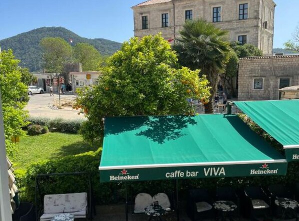 Ein Heineken-Gastgarten mit Blick auf ein historisches Gebäude und einen Berg im Hintergrund.