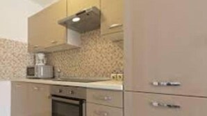 A kitchen with a microwave, oven, and cabinets. - Apartment Kancijanić (Vodnjan)