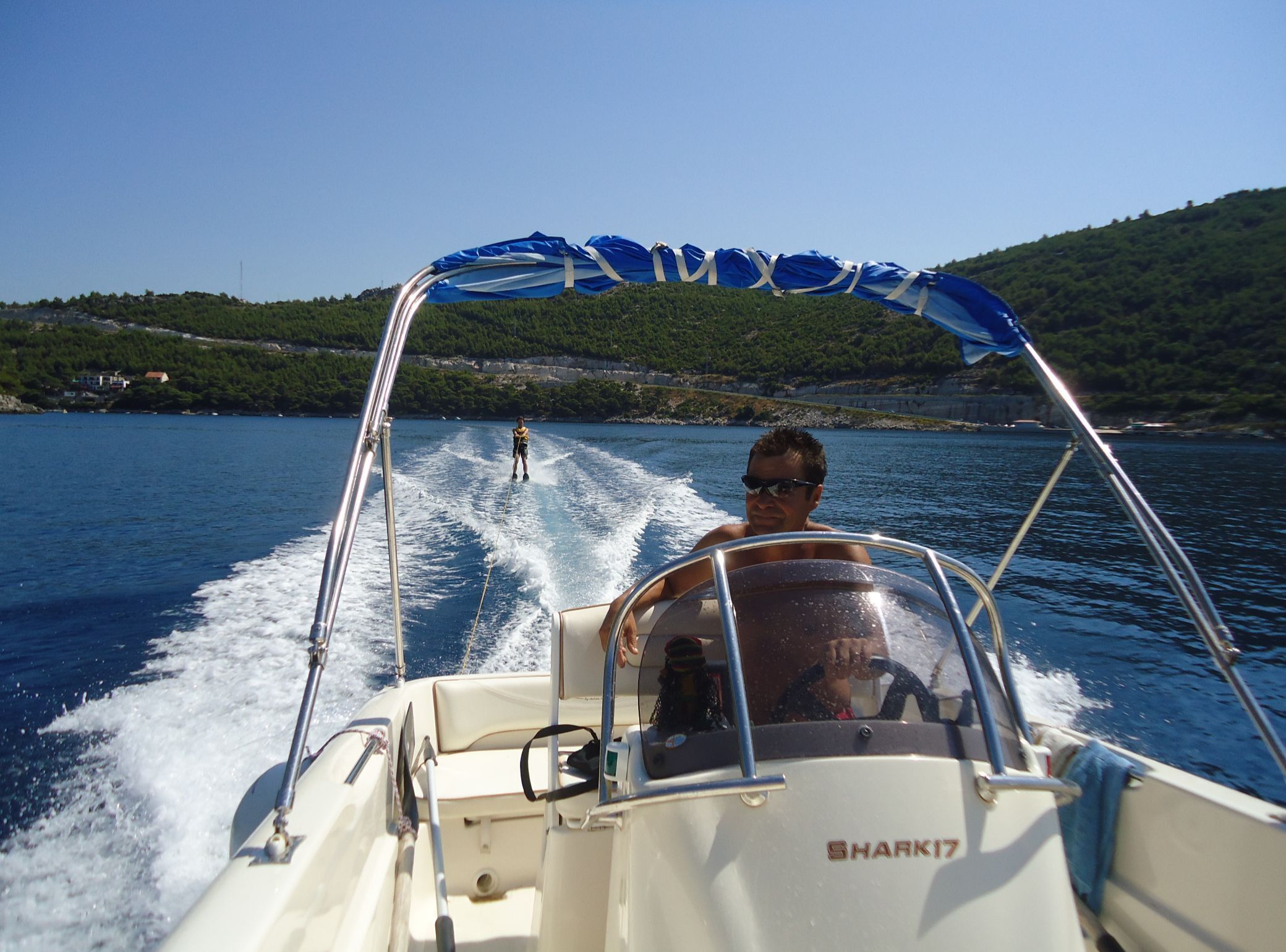 A boat with a canopy and the name 'SHARK17' on the side.