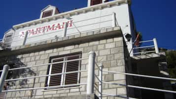 A building with a sign that reads 'PARTMAI' and a stone facade.
