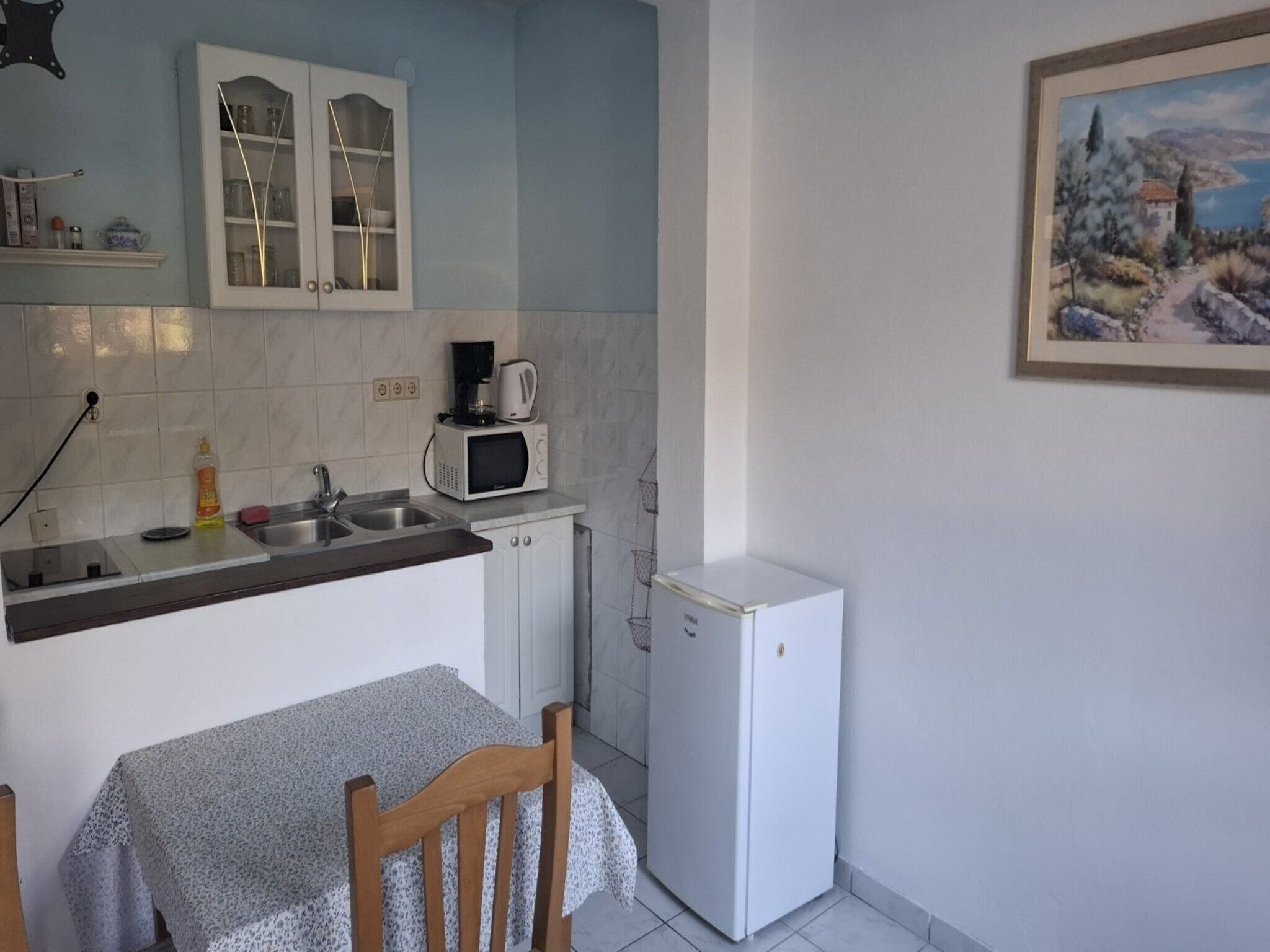 A compact kitchen with a microwave, coffee maker, and a small refrigerator.