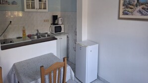 Une cuisine compacte équipée d’un four à micro-ondes, d’une machine à café et d’un petit réfrigérateur.