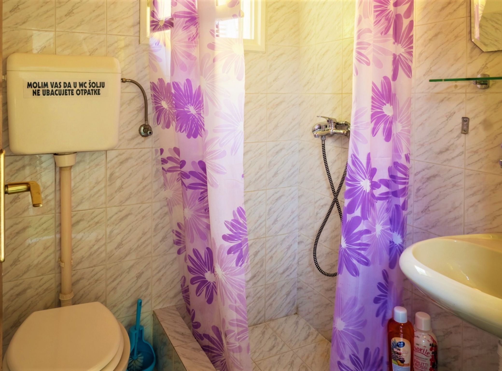 Une salle de bain avec des toilettes, un rideau de douche et un lavabo.