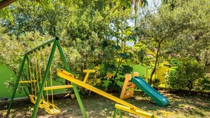 A playground with swings, a slide, and climbing structures. - Nirvana Apartments & Auto Camp (Kumbor)