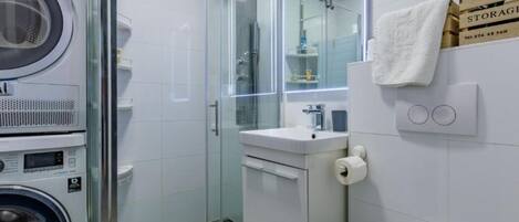 A modern bathroom with a glass shower enclosure, a built-in sink, and a toilet.